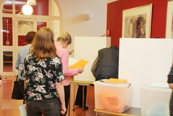 Menschen vor Wahlkabine